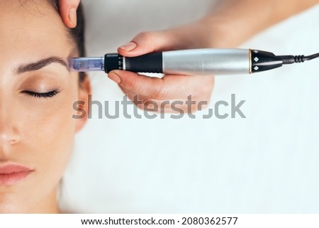 Shot of cosmetologist making mesotherapy injection with dermapen on face for rejuvenation on the spa center. Royalty-Free Stock Photo #2080362577