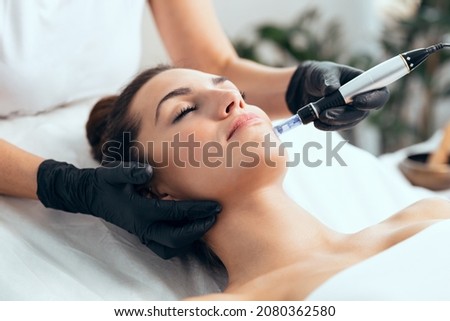 Shot of cosmetologist making mesotherapy injection with dermapen on face for rejuvenation on the spa center. Royalty-Free Stock Photo #2080362580