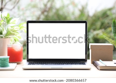 laptop mock up white blank screen with gift box and juice on wooden desk