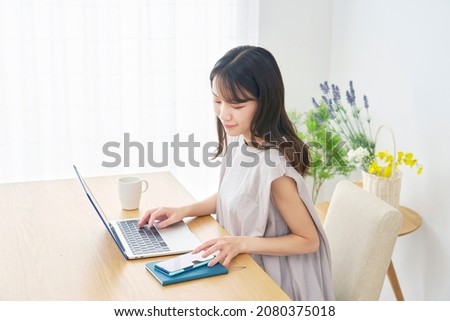 Asian woman using the laptop at home