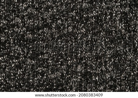 Black fibrous stockinette knit texture with metallic fibers as background