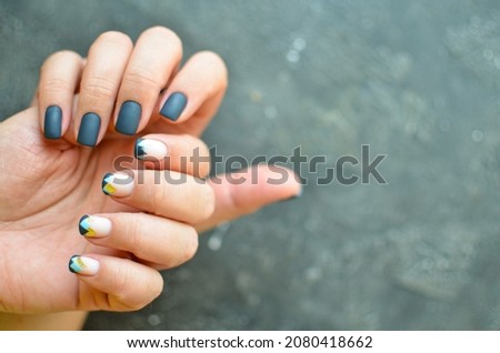 Woman's hands with colorful pattern on the nails. 2022 colors trend. Top view. Place for text. Cozy winter design.