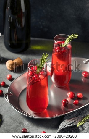 Boozy Holiday Cranberry Champagne Poinsettia Cocktail with Rosemary Royalty-Free Stock Photo #2080420288