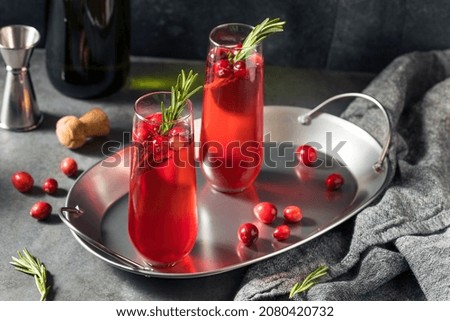 Boozy Holiday Cranberry Champagne Poinsettia Cocktail with Rosemary Royalty-Free Stock Photo #2080420732