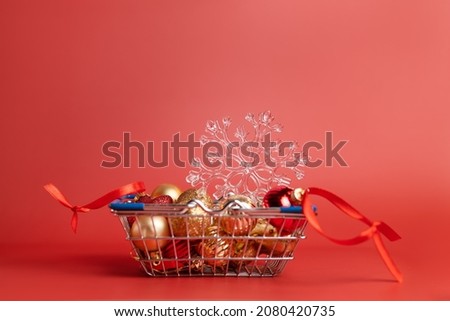 Basket of Christmas toys on a red background - balls, stars and snowflake, red and gold. High quality photo