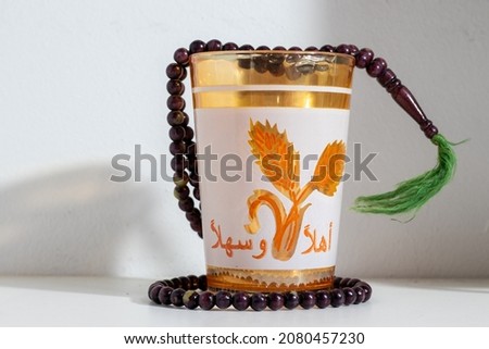 English Translation: "Welcome"
Arabic coffee glass and islamic pray rosary