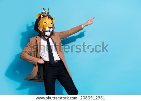 Photo of weird eccentric guy lion mask character point hand empty space offer theme event isolated over blue color background
