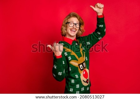 Photo of sweet impressed young guy dressed print pullover glasses pointing looking empty space smiling isolated red color background