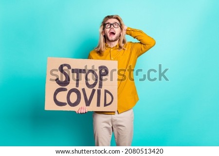 Photo of young guy irritated yell hold placard stop coronavirus protest strike quarantine isolated over teal color background