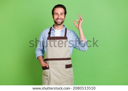 Photo of young man show fingers okey symbol approve quality service employment staff isolated over green color background