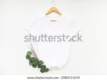 White t shirt on hanger with eucalyptus isolated on white background. Simple white t shirt mock up for your design
 Royalty-Free Stock Photo #2080515634
