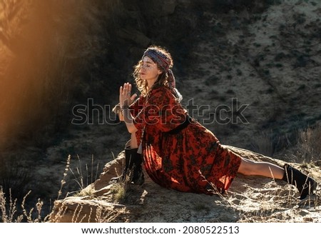 A woman in a turban does yoga in the rays of the setting sun