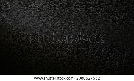 Macro shot of detailed black leather background. Dark textured close-up on quality leather parchment. Can be used in the background for luxury products and designs. Royalty-Free Stock Photo #2080527532
