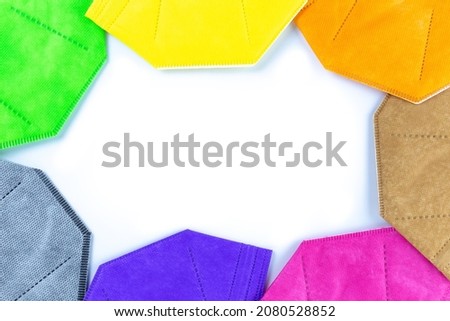 A Copy space round stack of  different colors face masks respirators Copy space on white background. Top view flat layer. Protection from covid virus during pandemic.