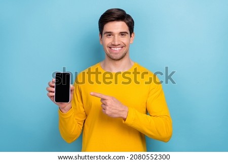 Photo of influencer guy point finger new smartphone device bargain option isolated over blue color background