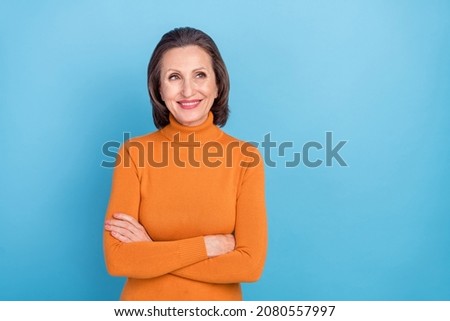 Photo of cheerful charming lady folded hands toothy smile look empty space isolated on blue color background