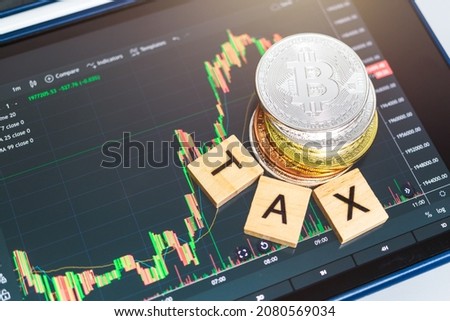 Cryptocurrencies with TAX word and stock chart candlestick on tablets background, Digital money concept Royalty-Free Stock Photo #2080569034