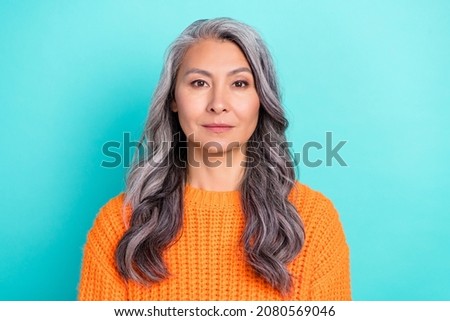 Portrait of attractive content calm grey-haired woman wearing orange pullover isolated over bright teal turquoise color background Royalty-Free Stock Photo #2080569046