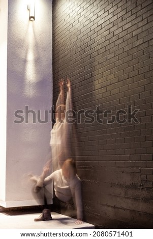 Passing the time - long exposure of a dancer under a light against a dark background