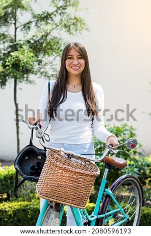 Portrait of a young woman smiling on a sunny day with her bicycle