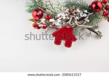 Beautiful Christmas background: decorative house and key to the lock on white background, flat lay. Space for text. Concept of finance and housing loans. Top view