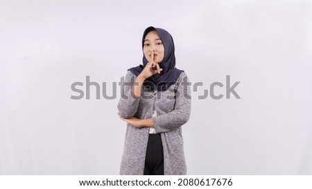 young asian woman gesturing silent isolated on white background