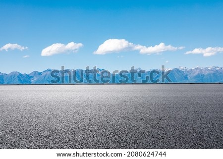 Asphalt road and mountain under blue sky