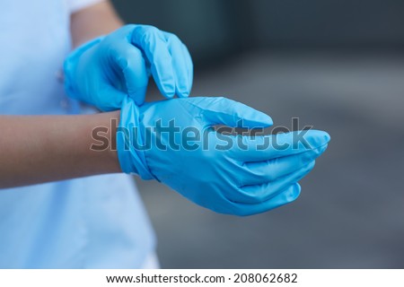 woman doctor wears medical gloves  Royalty-Free Stock Photo #208062682