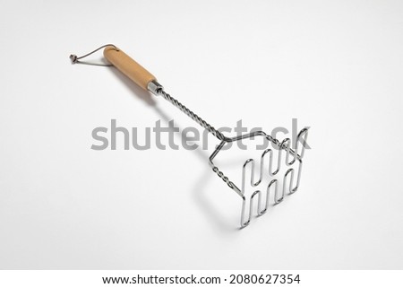 Stainless steel Potato masher with 
wooden handle isolated on white background.Potato pestle. High resolution photo.