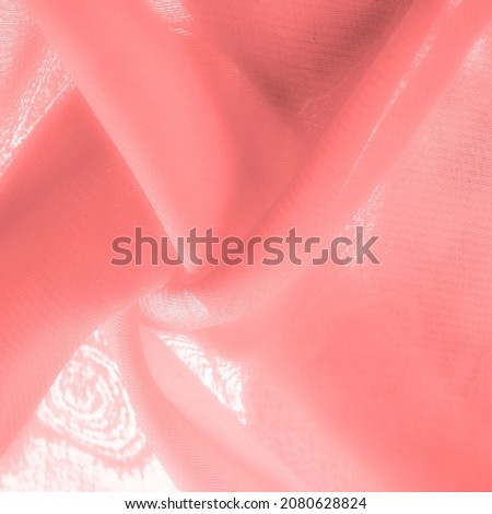 red pink silk fabric. a fine, strong, soft, lustrous fiber produced by silkworms in making cocoons and collected to make thread and fabric. Texture. Background.