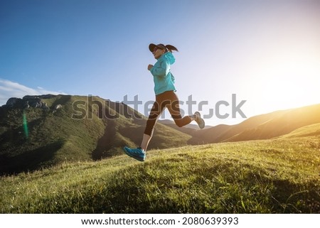 Young woman ultramarathon runner running at mountain top Royalty-Free Stock Photo #2080639393