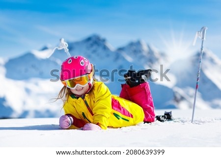 Child skiing in mountains. Active toddler kid with safety helmet, goggles and poles. Ski race for young children. Winter sport for family. Kids ski lesson in alpine school. Little skier racing in snow Royalty-Free Stock Photo #2080639399