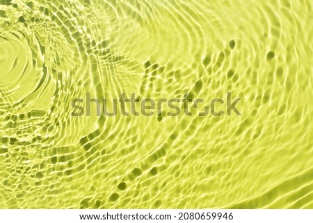 Water spills on a light green yellow background. Beautiful bursts and glare. Summer mood. Minimal style. Natural sunlight and shade. Backdrop for cosmetic ideas