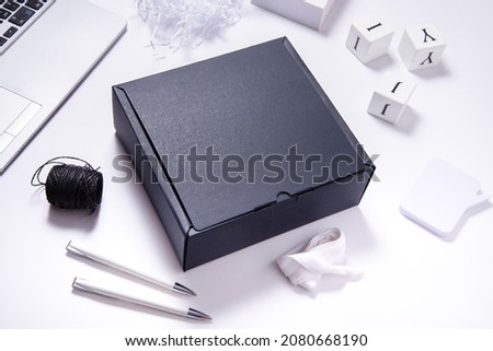Black carton cardboard box top view, on office desk