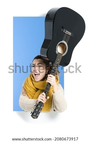 Angry musician threatening with an acoustic guitar