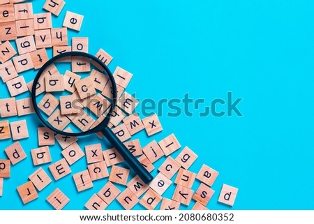 English alphabet made of square wooden tiles with the English alphabet scattered on blue background. The concept of thinking development,grammar. Royalty-Free Stock Photo #2080680352