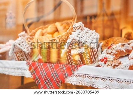 A bakery showcase in a European city for Christmas. Gingerbread house, pretzel, apple crumble, buns. Bread on Christmas and New year