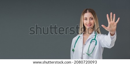 Beautiful blonde medical doctor woman portrait. She is confident mood and looking to camera and show her five fingers, tips and tricks concept. Includes copy space.