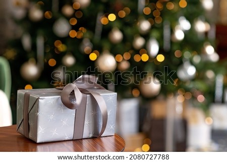 Christmas and New Year background - gift boxes, presents, against the background of bokeh lights of a decorated Christmas tree. Soft selective focus.