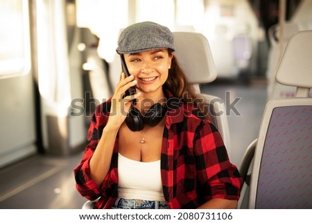 Young woman travelling by train. Beautiful girl talking to the phone while travel	