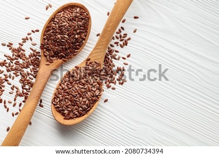 Wooden spoons with flaxseed on a white wooden background. Top view. Copy space. Royalty-Free Stock Photo #2080734394
