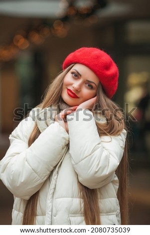 Christmas street style portrait of young beautiful fashion woman walking in European city on winter holidays. Stylish model in casual clothes with long hair is doing New Year's shopping. Season.