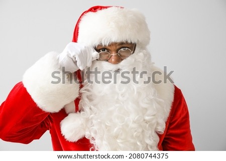 African-American Santa Claus on light background Royalty-Free Stock Photo #2080744375