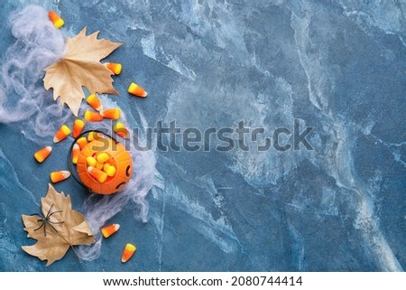 Halloween composition with tasty candy corns on dark background