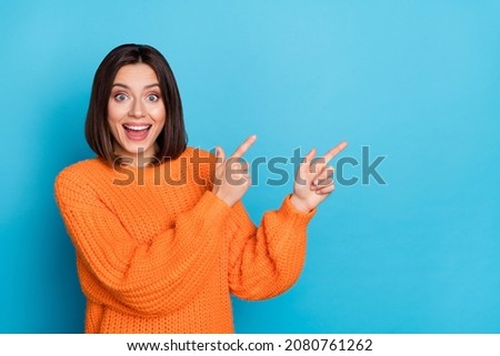 Portrait of attractive funny amazed cheerful girl demonstrating copy space novelty isolated over bright blue color background