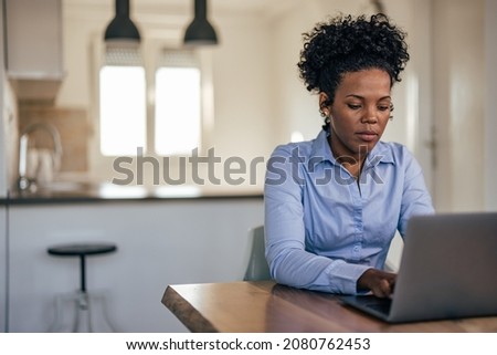Focused african-american woman, working on her project at home office Royalty-Free Stock Photo #2080762453