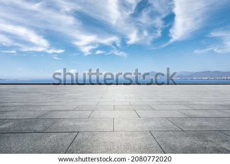 Empty square floor and river with mountains under blue sky Royalty-Free Stock Photo #2080772020