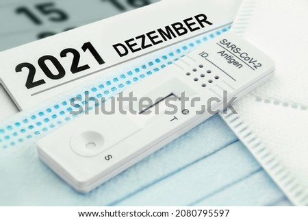 German calendar 2021 December and Corona Rapid Antigen Test with various face masks