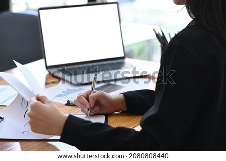 Cropped shot businesswoman writing information on document.