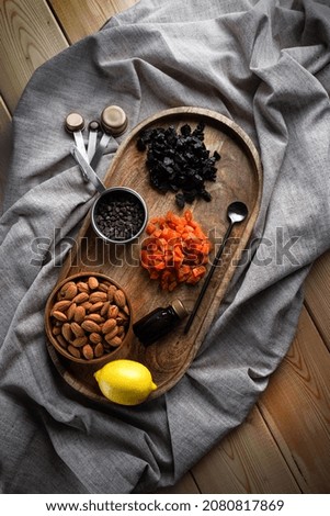 Natural ingredients for a recipe for making Italian biscotti on a wooden tray with tablecloth .